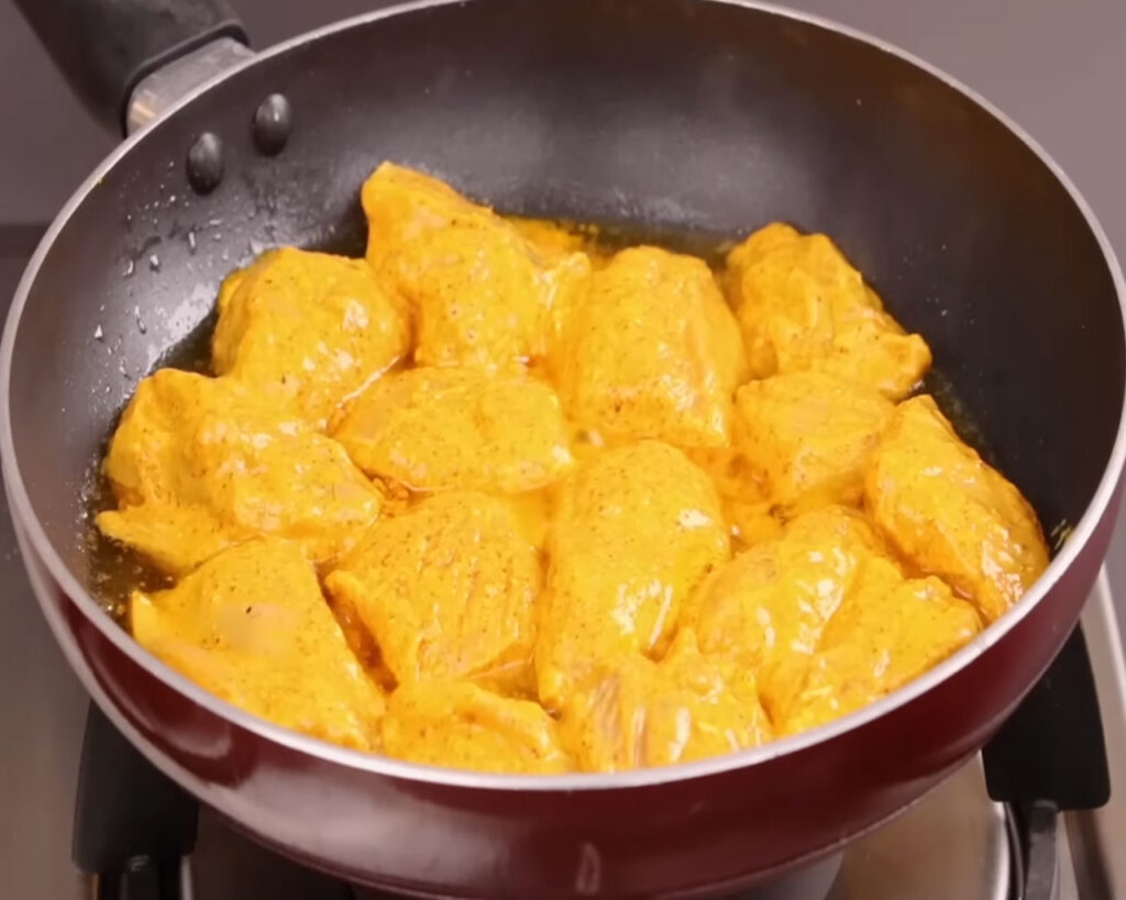 Cooking marinated chicken in oil for chicken tikka masala