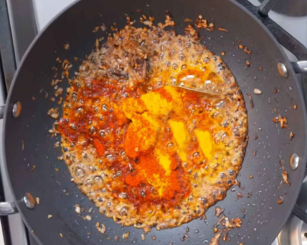 Ginger garlic paste, red chili powder, and turmeric added to sautéed onions for paneer butter masala