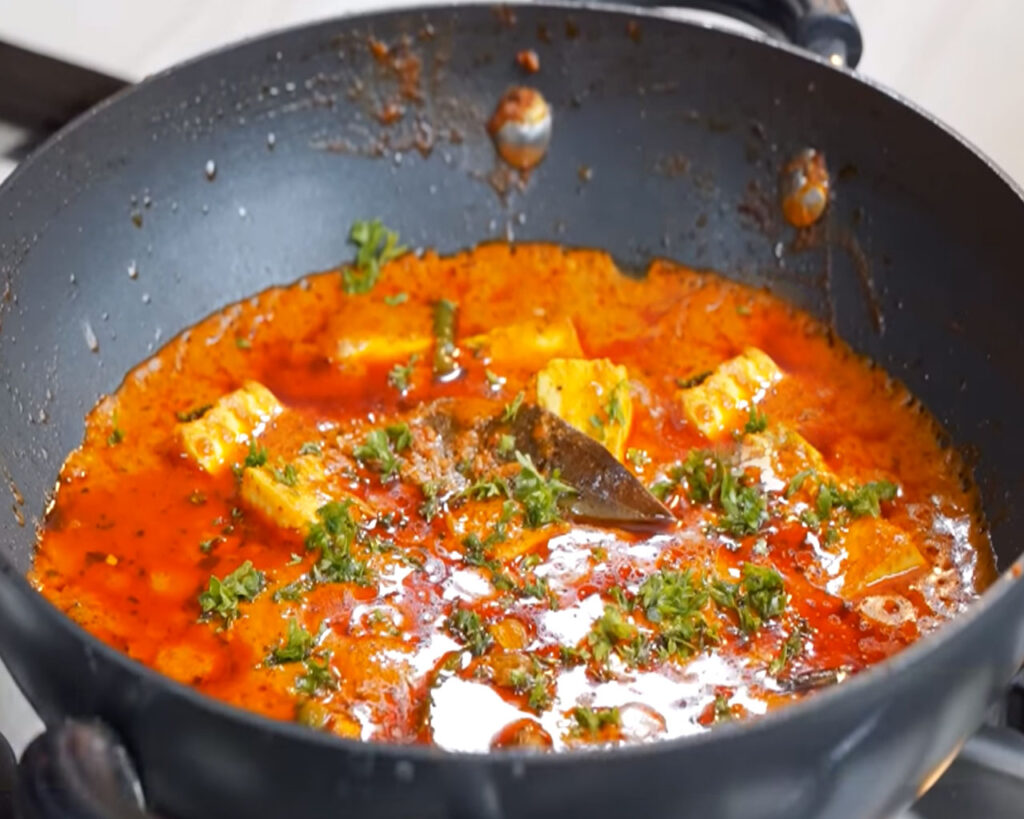Paneer butter masala garnished with fresh coriander leaves ready to be served with naan or roti