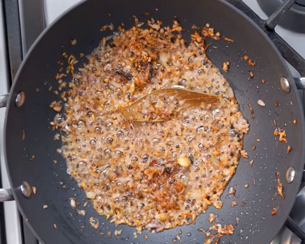 Finely chopped onions turning golden brown in a pan for butter masala gravy base