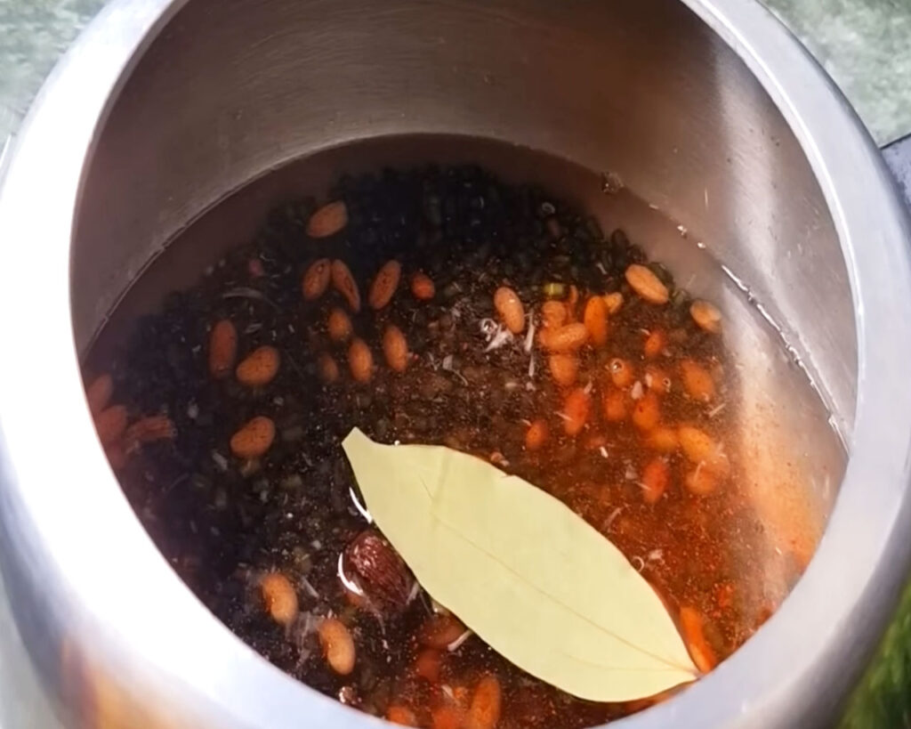 Lentils and spices cooking in a pressure cooker with water for Dal Makhani recipe