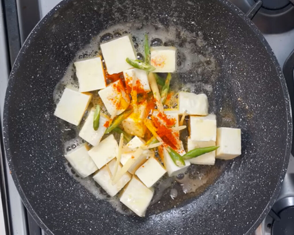 Seasoned paneer cubes with green chilies, red chili powder, turmeric, and ginger juliennes