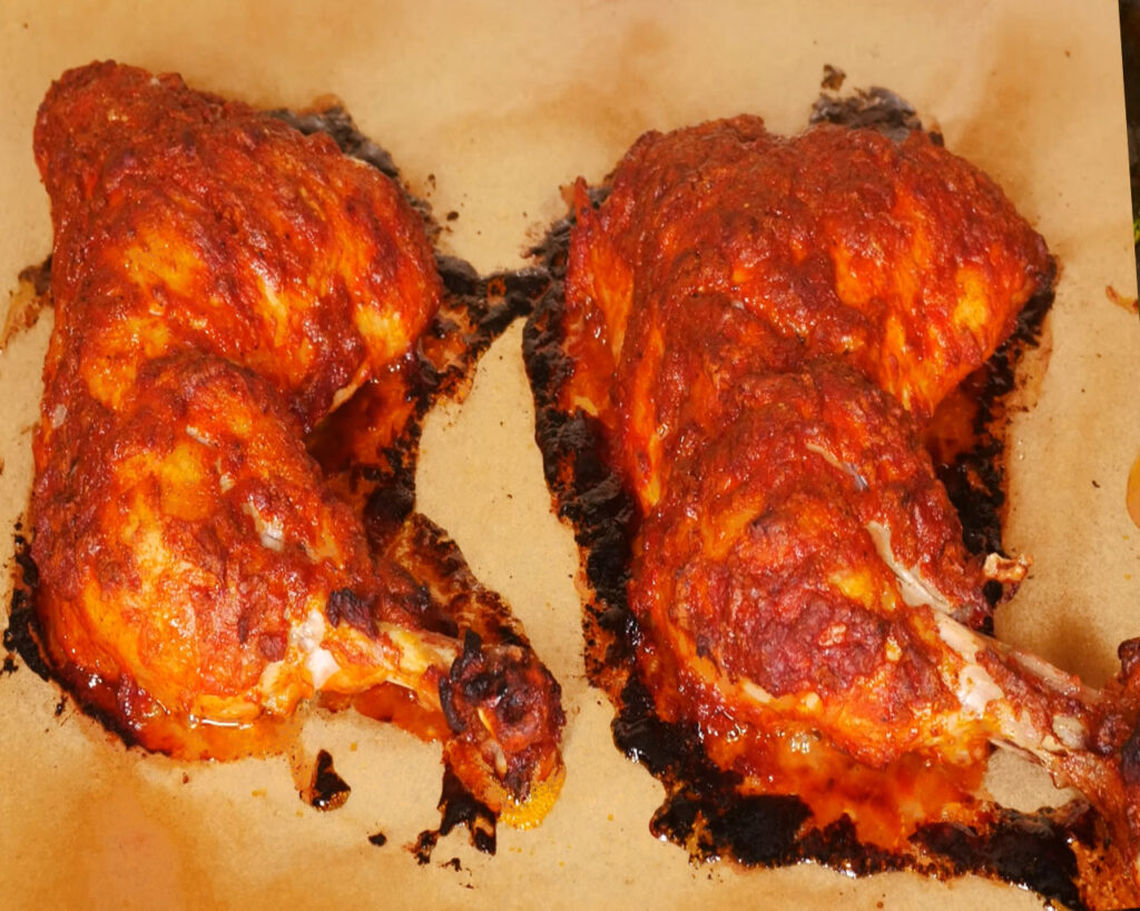 Baked tandoori chicken on baking tray