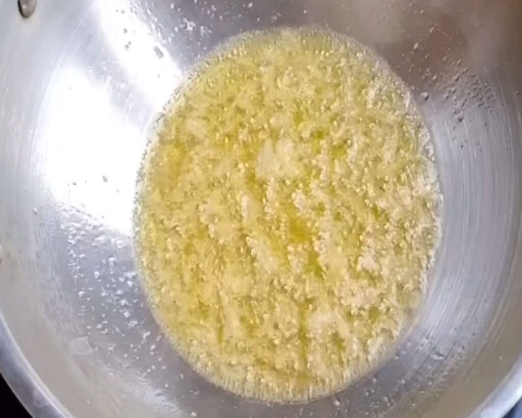 Garlic and ginger paste frying in hot ghee in a pan