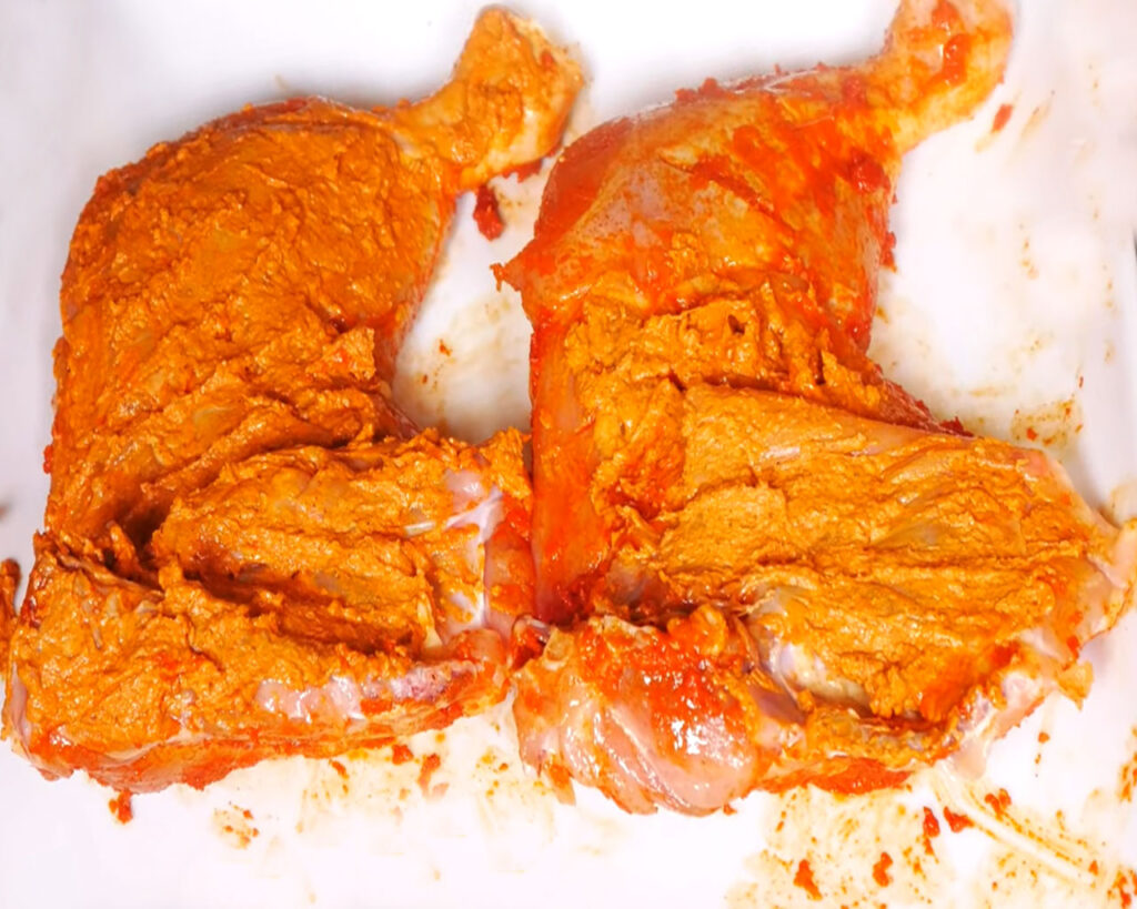 Chicken pieces coated in thick yogurt spice marinade ready for refrigeration