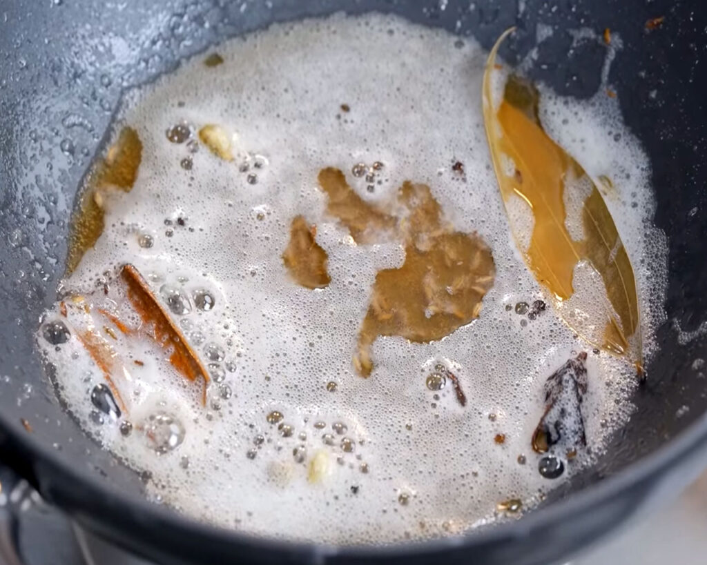 Cumin seeds, cardamom, cinnamon, and cloves sizzling in oil and butter for paneer butter masala