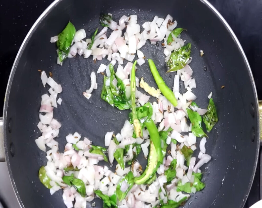 add cumin seeds, curry leaves, chopped onions in pan for poha