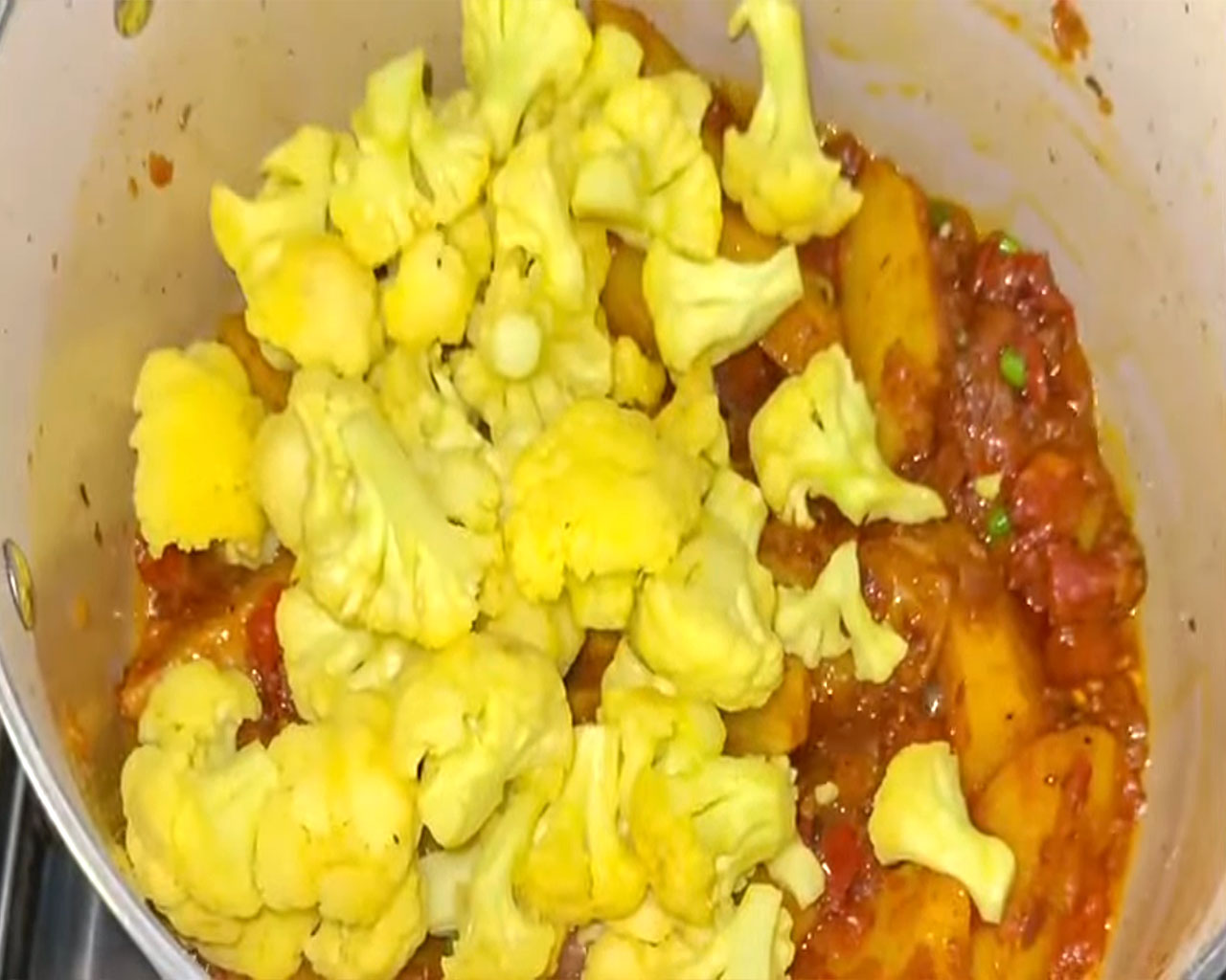 Mixing cauliflower with spiced potato gravy