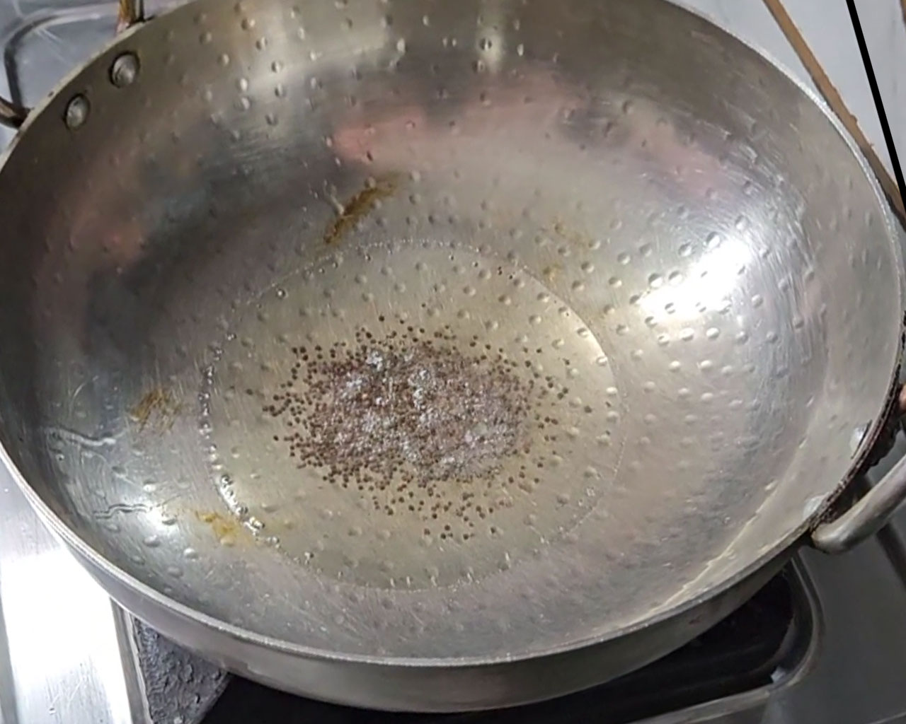 Mustard seeds and cumin seeds cooking in hot oil