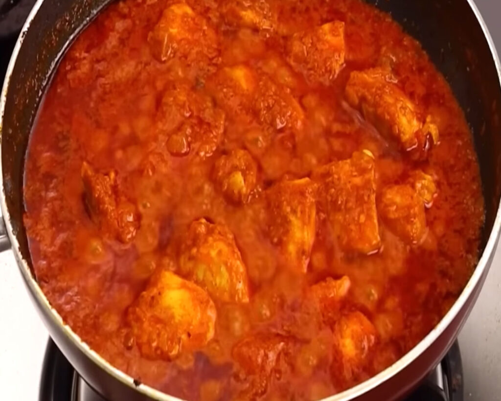 Cooking chicken tikkas in masala sauce until fully cooked