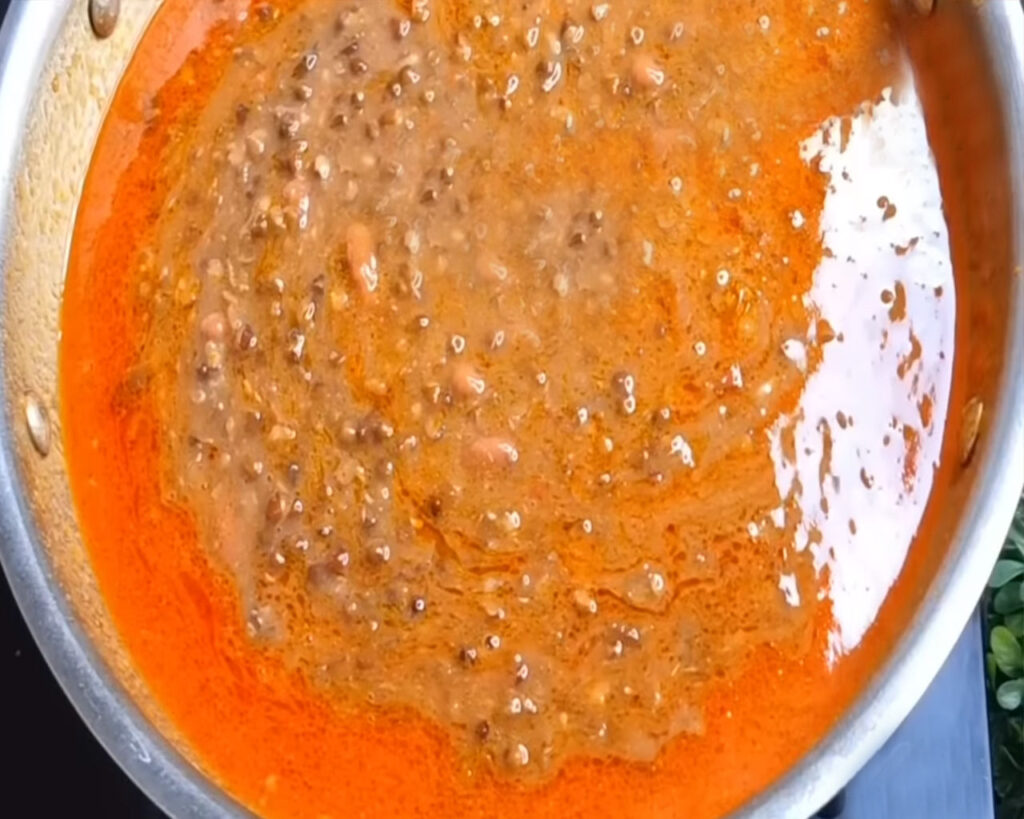 Dal Makhani being cooked with tomato paste