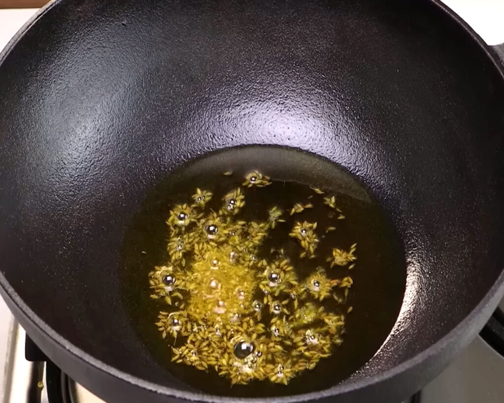 Cumin seeds frying in pan in hot mustard oil for Rajma Masala recipe
