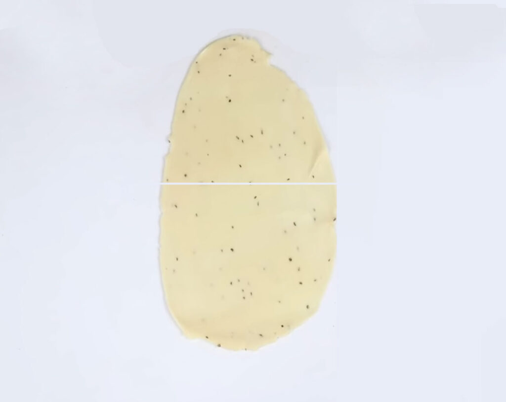 put dough on flat surface and make oval shape and cut in half for samosa filling