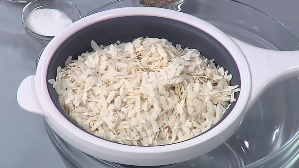 Dry flattened rice (poha) in a bowl before rinsing, used for Kanda Poha