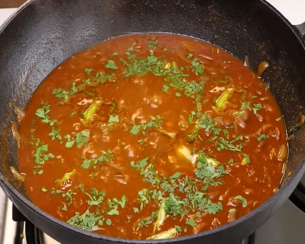 Rajma Masala garnished with chopped coriander, green chilies, and a teaspoon of ghee — ready to serve hot.