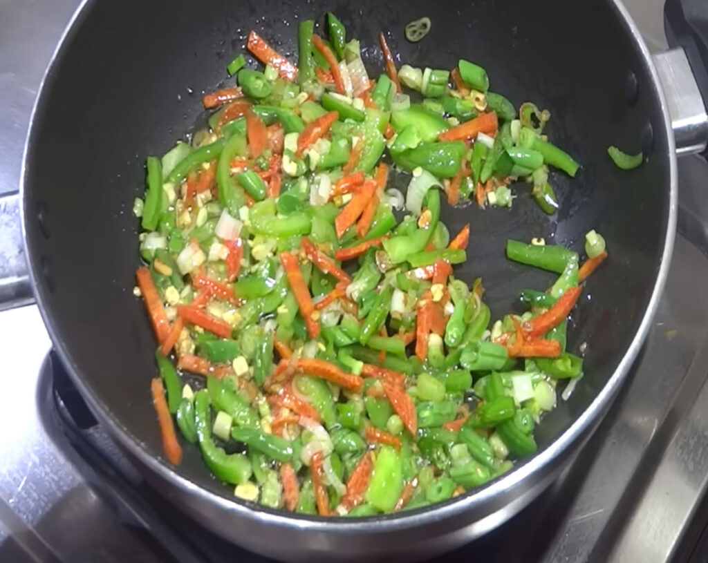 mixing veg fried rice ingredients in wok