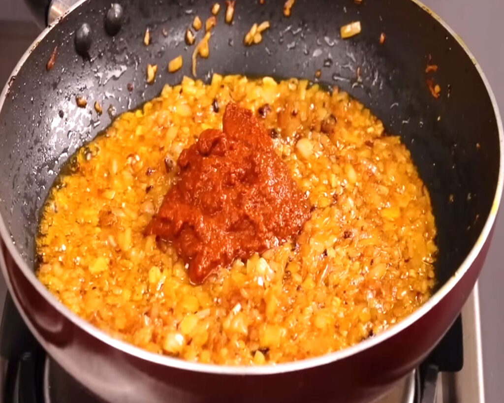 Preparing chicken tikka masla paste with onions in pan