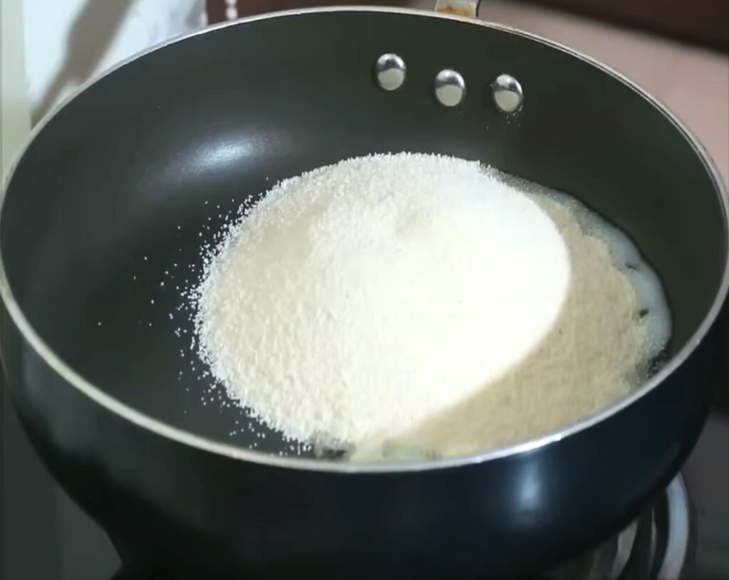 Roasting rava (semolina) in a pan until golden for making upma