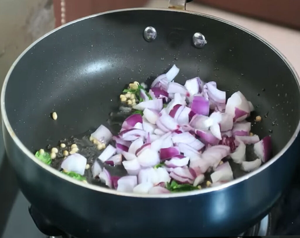 Chopped onions sautéing in pan for traditional South Indian upma