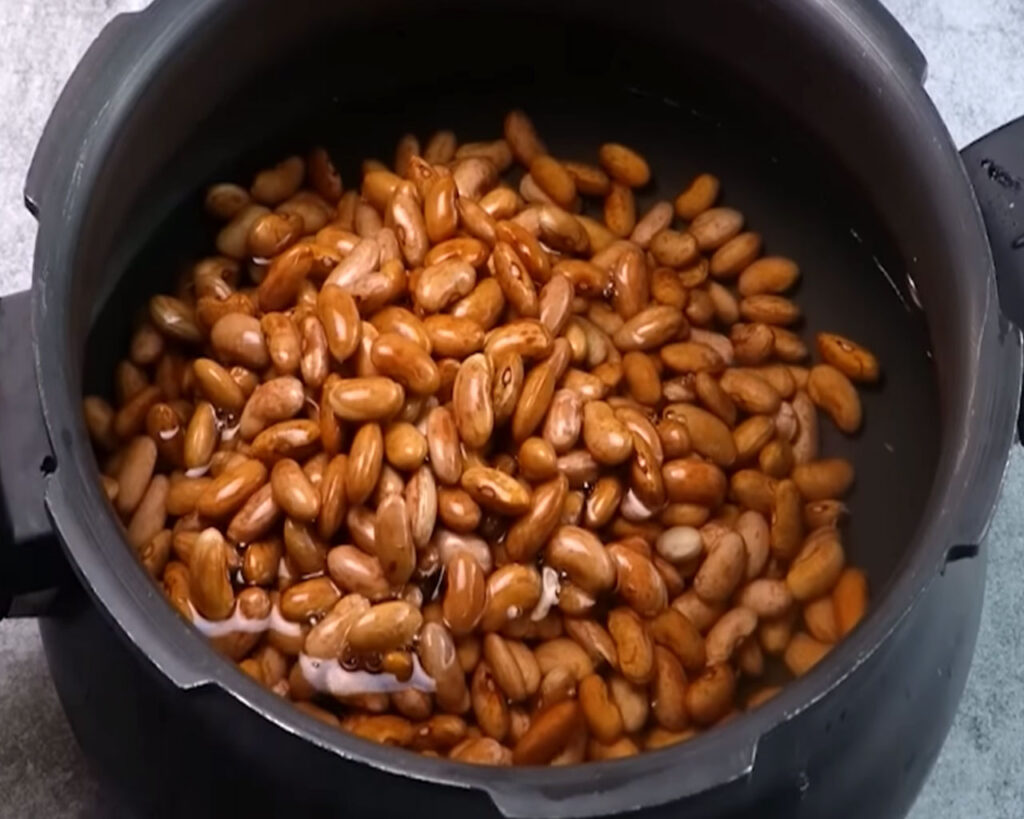 Rajma (kidney beans) soaked in water overnight to soften before cooking.