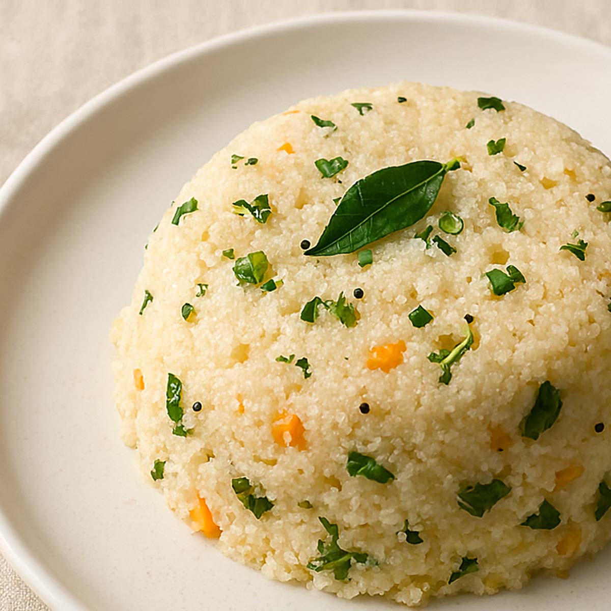 Close-up of soft and fluffy rava upma in a plate, topped with fried cashews and fresh coriander, a popular Indian breakfast dish.