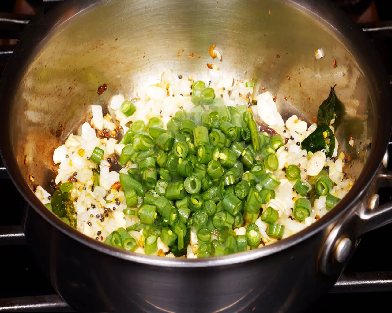 Adding chopped green beans to the onion mixture