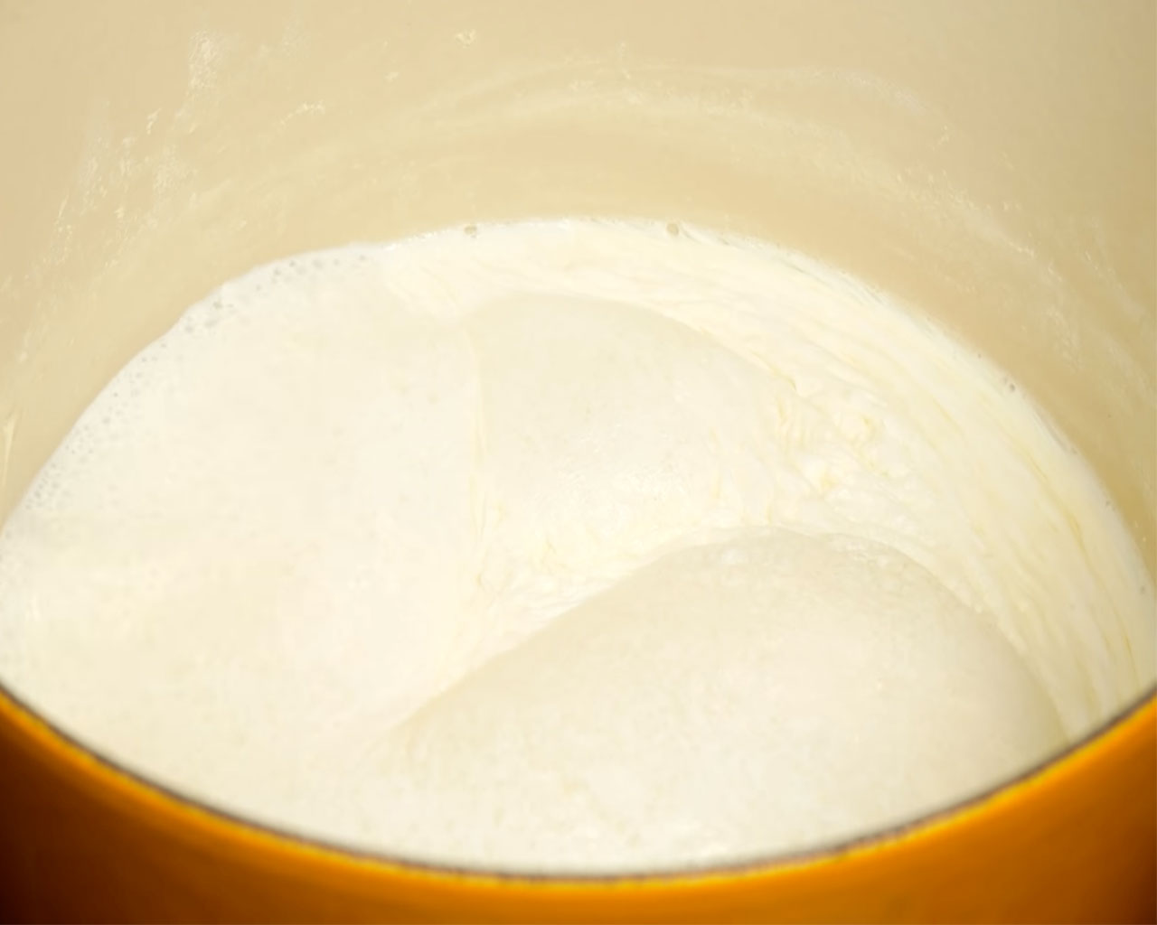 Whole milk boiling in a heavy-bottomed pot for making Indian rice pudding or kheer.