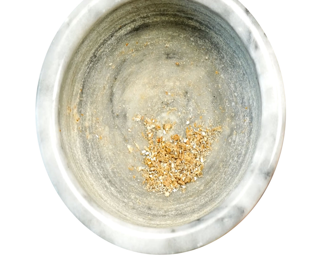 Crushed cardamom being added to thickened rice and milk mixture for kheer.