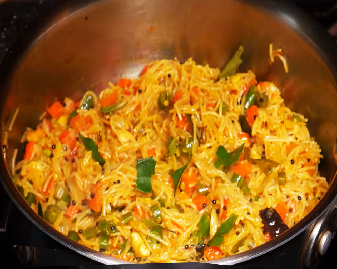 Garnishing cooked semiya upma with curry leaves