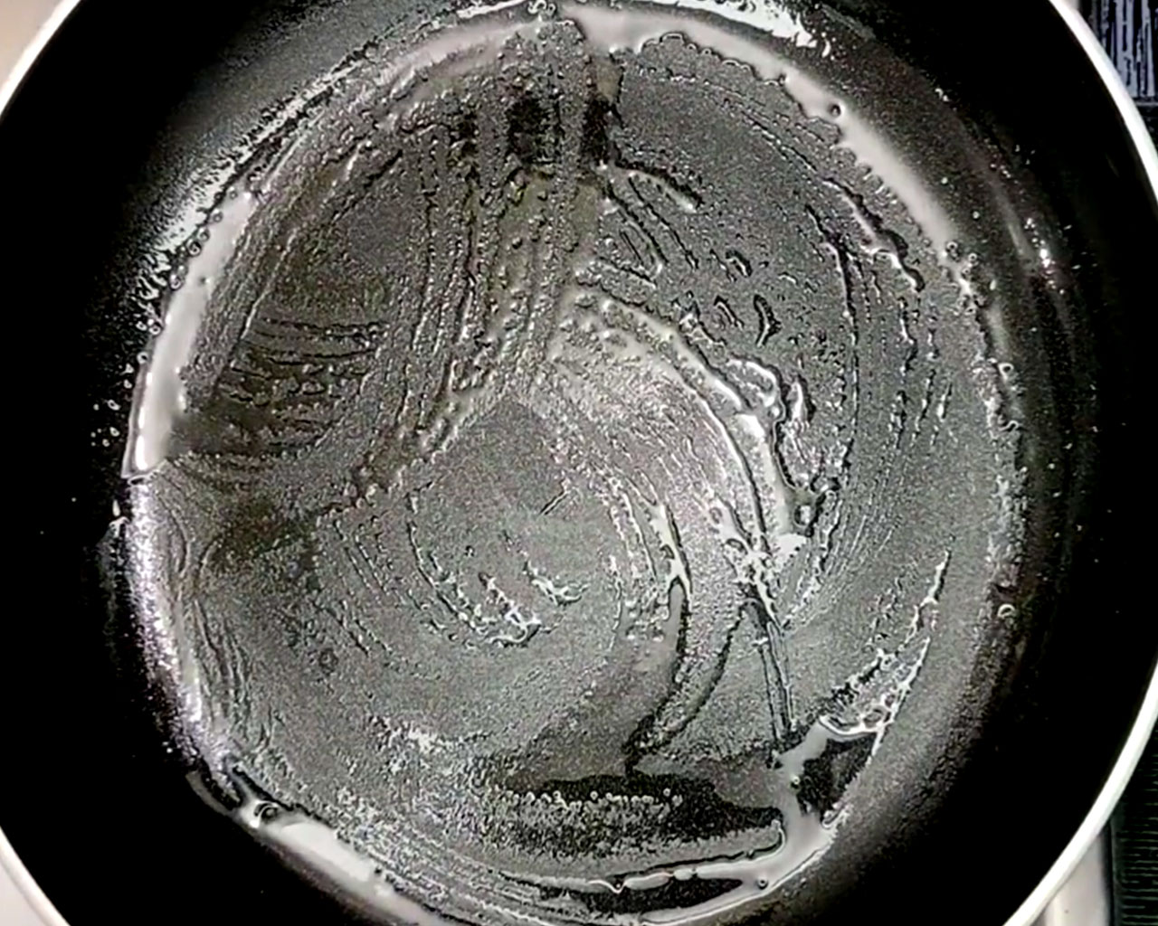 Heating a non-stick pan with oil to cook the chilla.