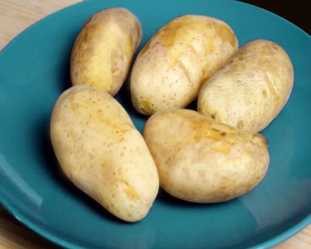 Boiling and cubing potatoes for Jeera Aloo preparation.