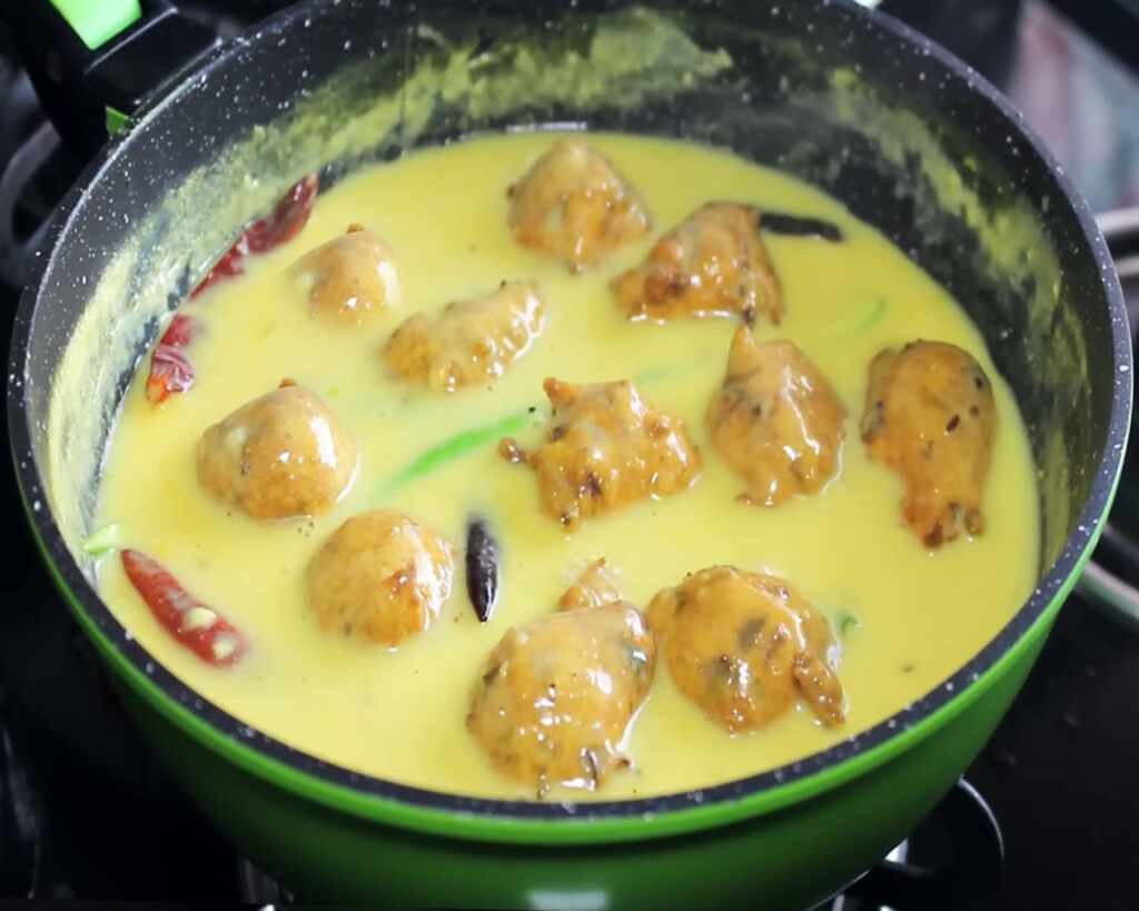 Kadhi Pakora recipe is being cooked in pan