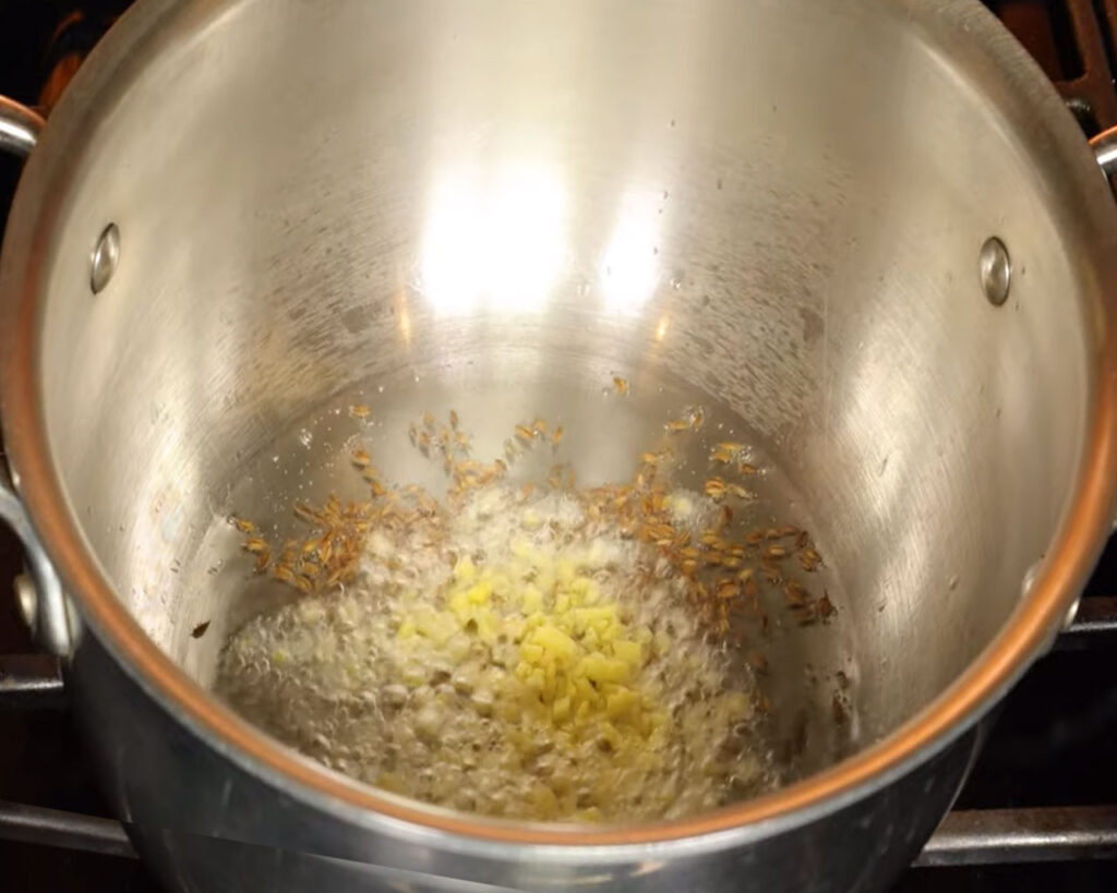 Chopped ginger sautéing in hot oil for Indian cauliflower curry base
