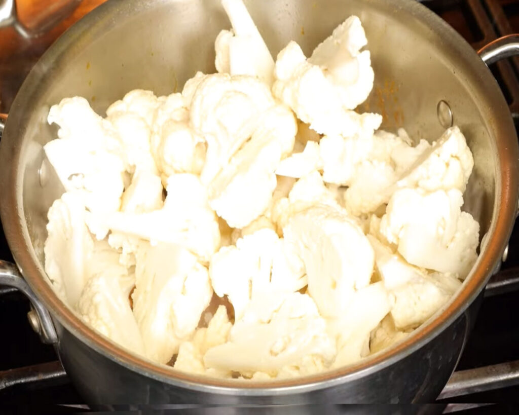 Cauliflower florets added into creamy tomato gravy for Indian curry