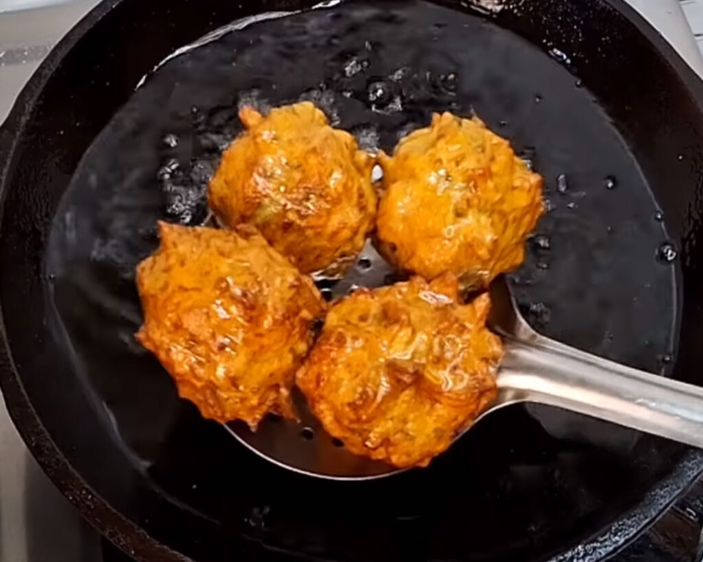 Golden brown fried lauki koftas coming out in plate