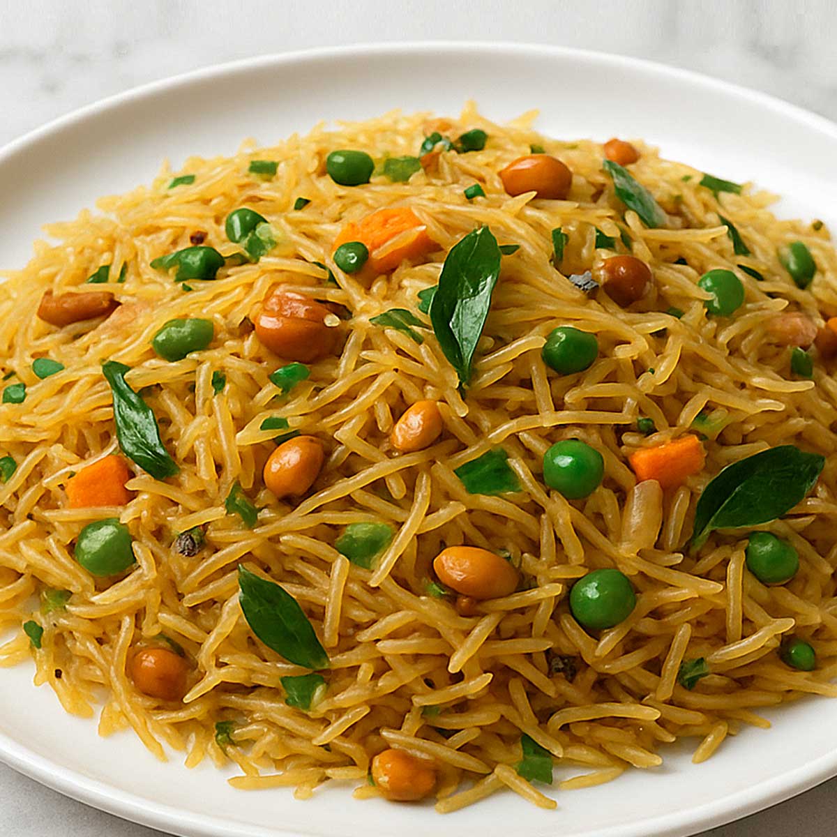 Healthy semiya upma breakfast served on a clean plate with golden cashews and fresh curry leaf garnish.