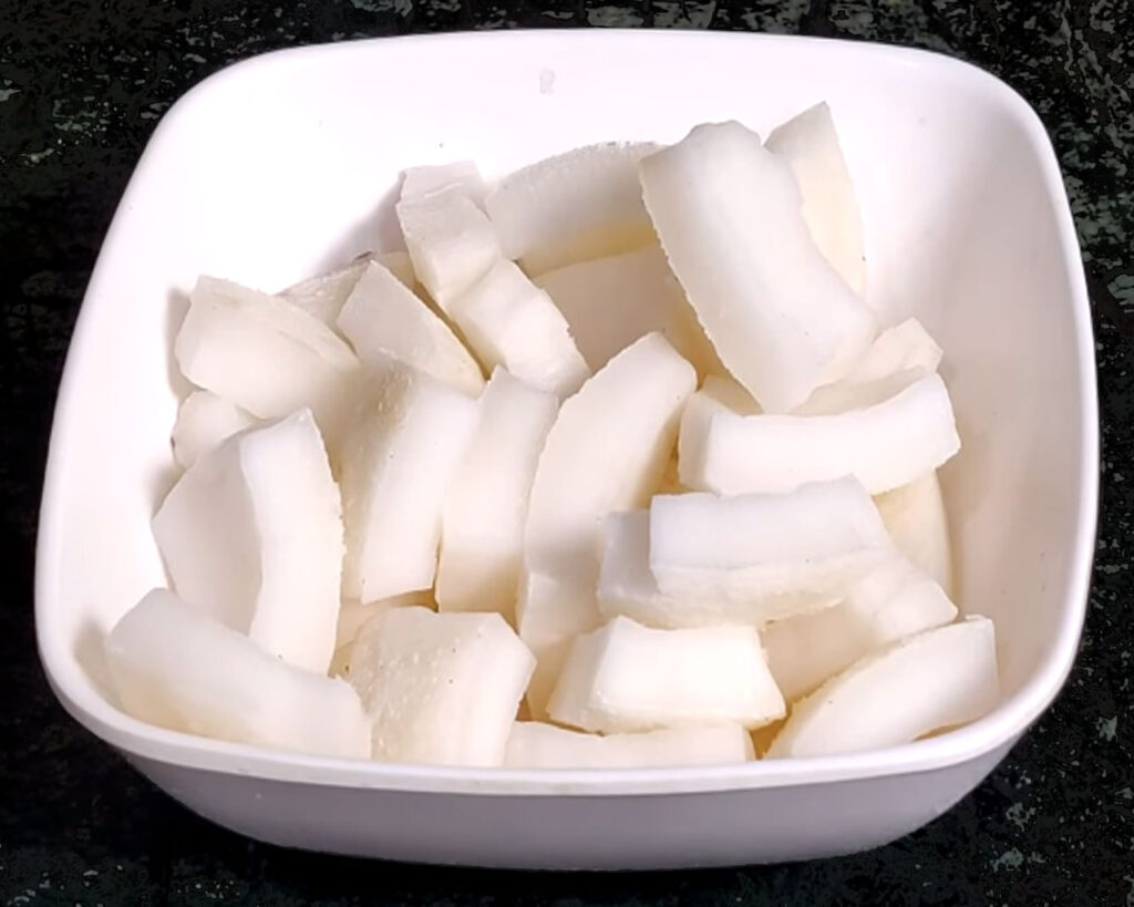 Fresh coconut broken open with white kernel pieces for making coconut chutney
