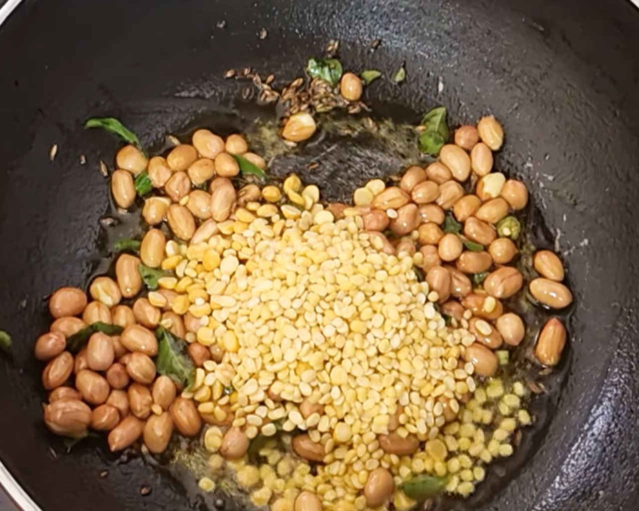 Urad dal being sautéed with peanuts and chilies