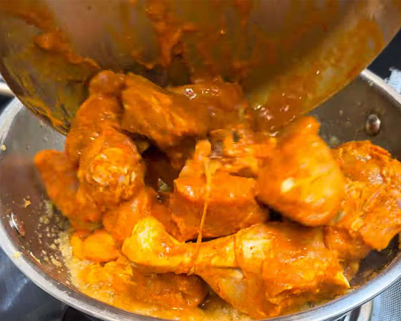 Marinated chicken being added to pan with sautéed onions