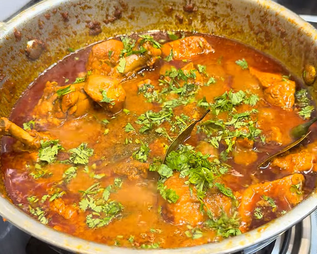 Garnished Indian chicken curry and ready to serve with naan