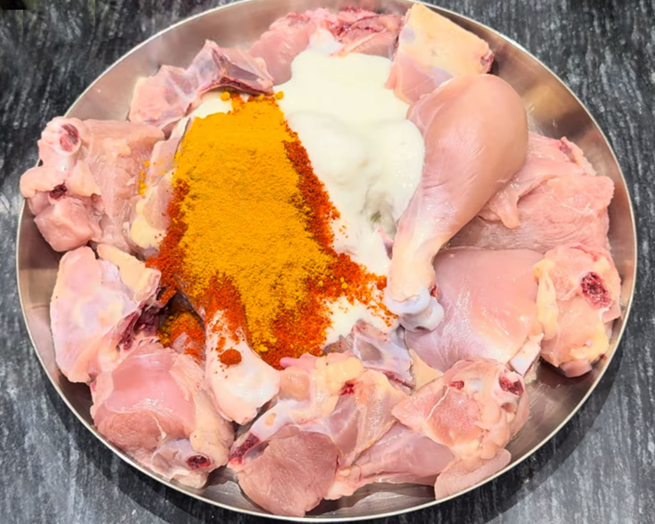 Raw chicken pieces for marination with Indian spices for Chicken Curry