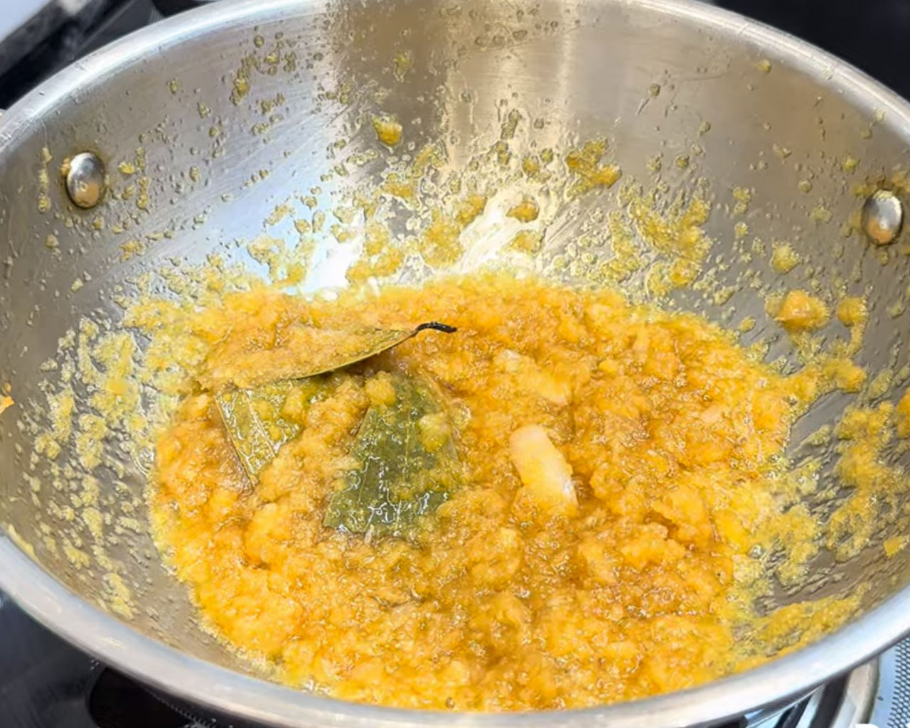 Golden brown grated onions cooking in oil for curry base