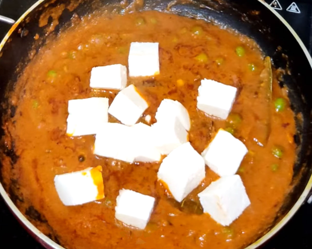 Paneer cubes added to the matar gravy, ready to be simmered for a rich, creamy texture