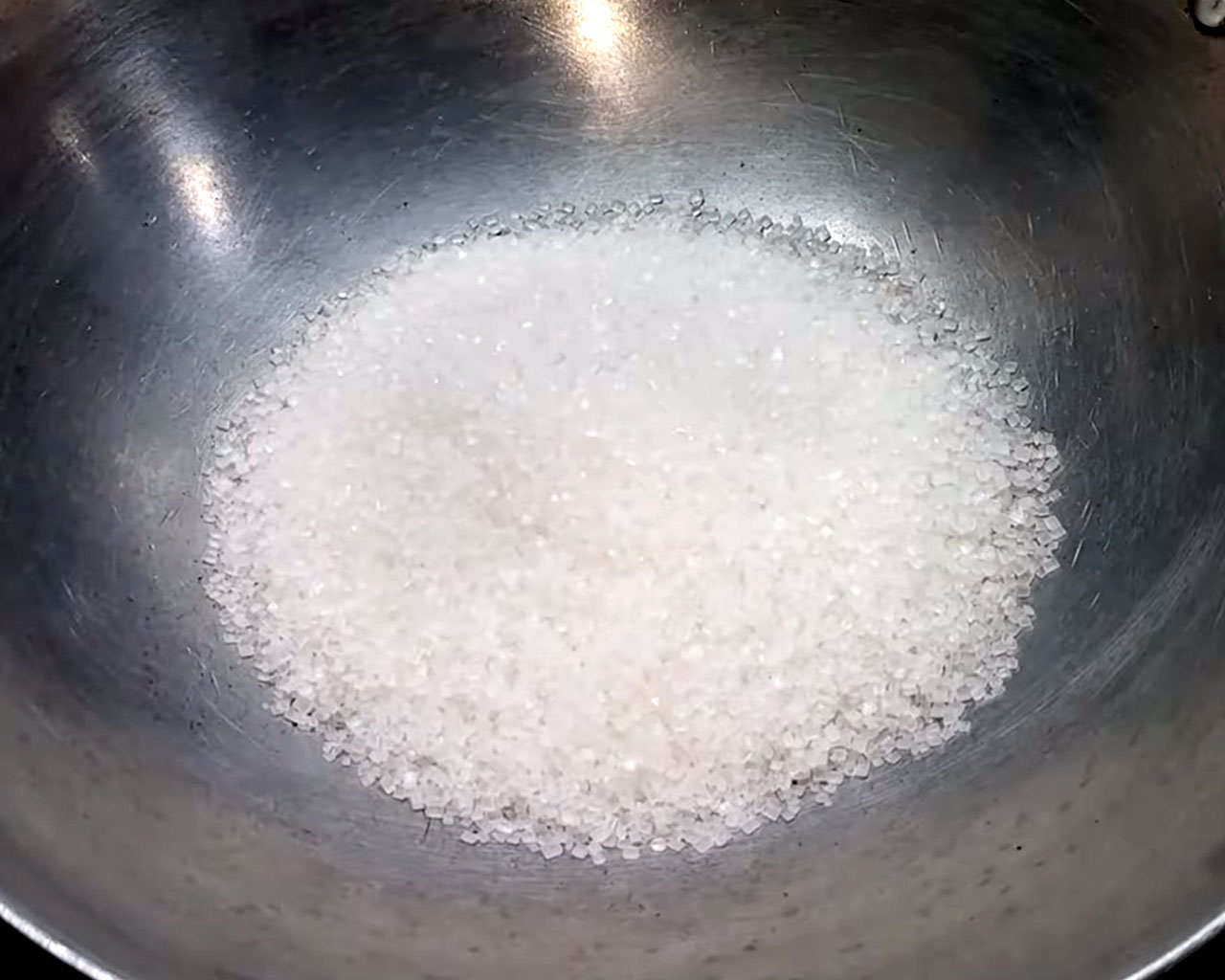 Sugar in a deep pan to make sugar syrup (chasni) for rasgulla.