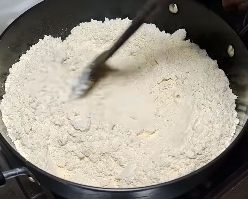 Dry roasting gram flour (besan) in a heavy-bottomed pan over medium flame for besan ladoo recipe