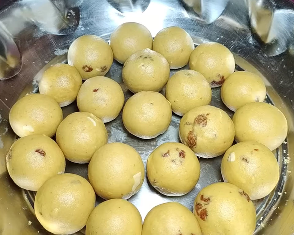 Hand-rolling the besan mixture into round ladoos, final step in besan laddu recipe