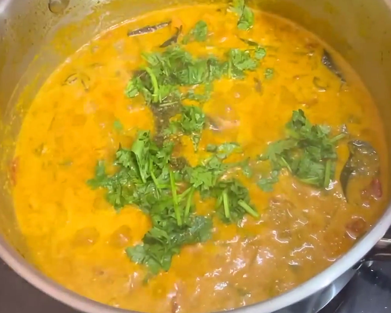 Finished vegetable kurma garnished with fresh coriander leaves