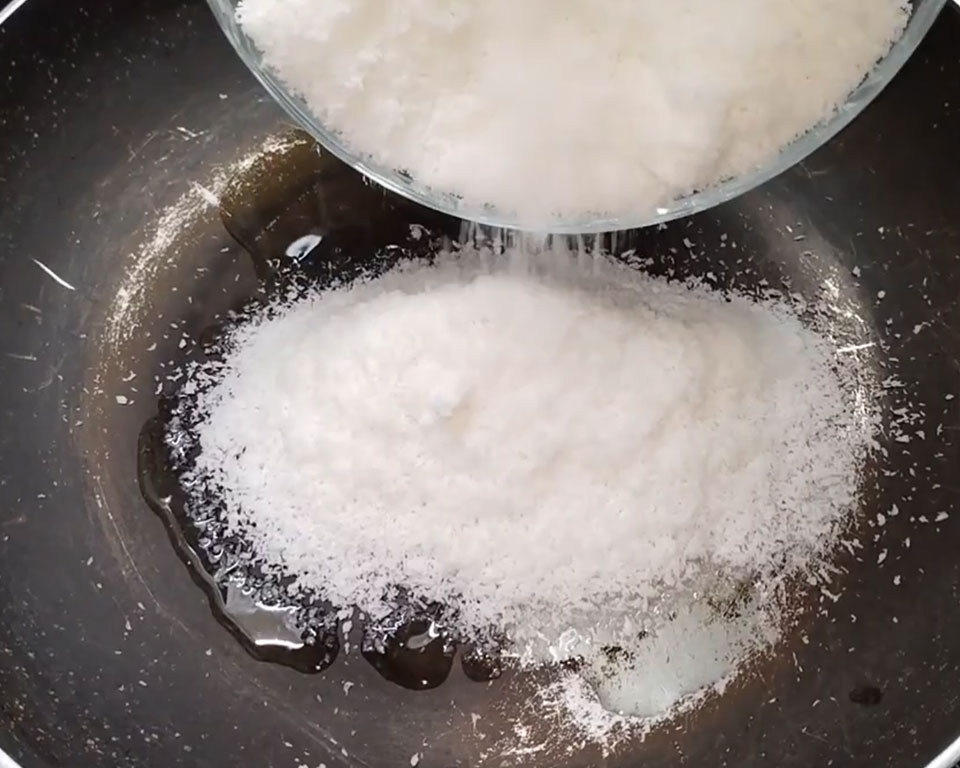 Adding desiccated coconut power in ghee for ladoo