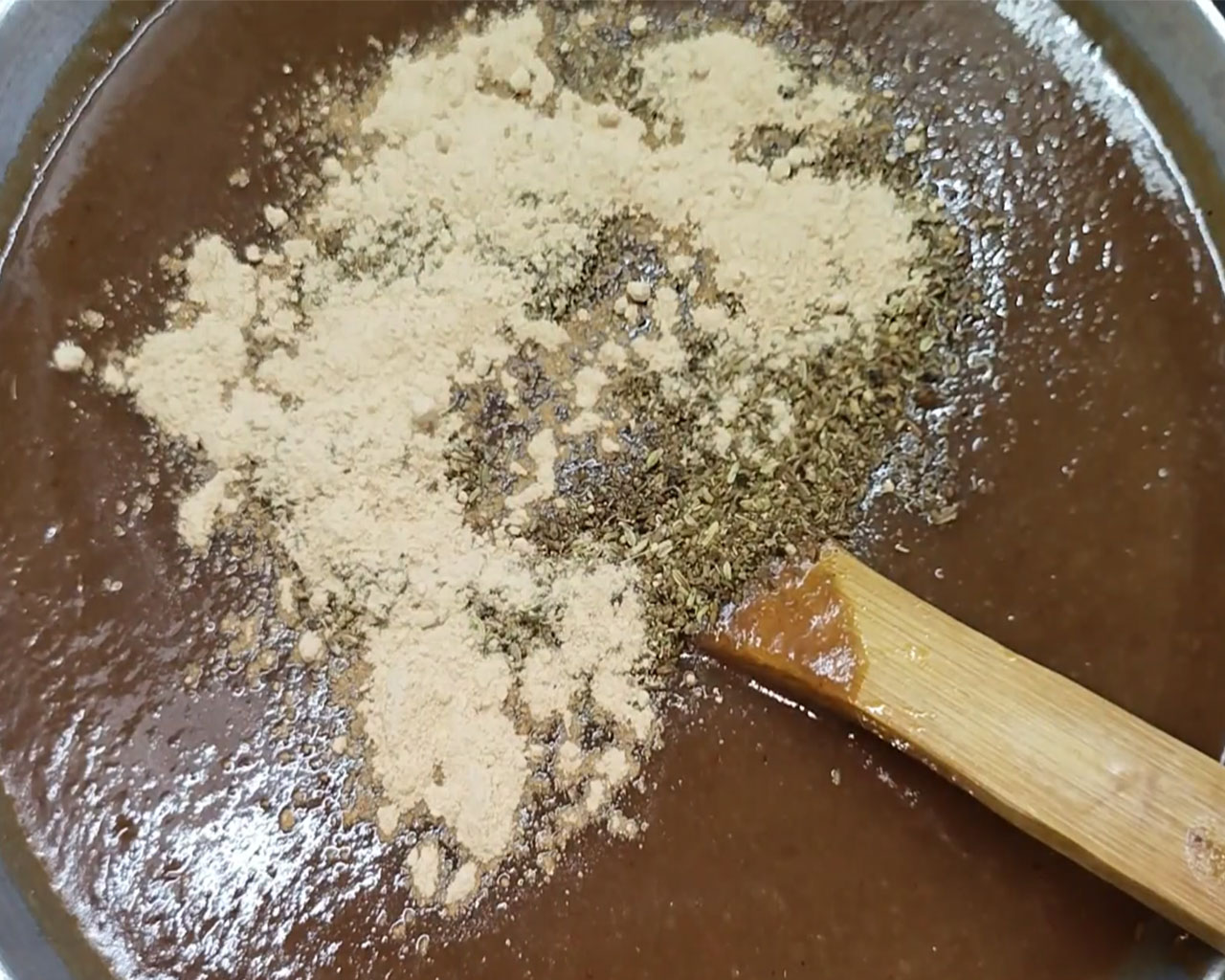 Saunth (dry ginger powder) being added to enhance flavor of tamarind chutney