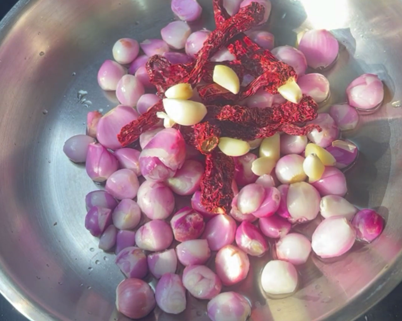 Garlic cloves being added to pan for onion chutney.